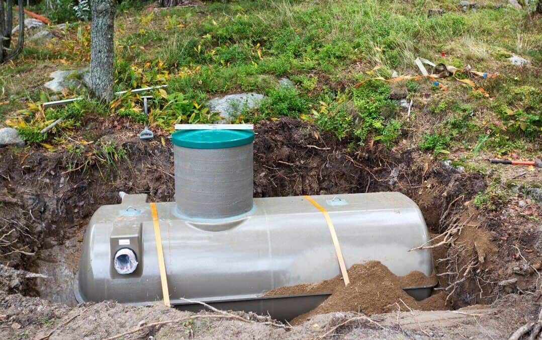 A fiberglass septic tank being buried in a hole ready to be used.