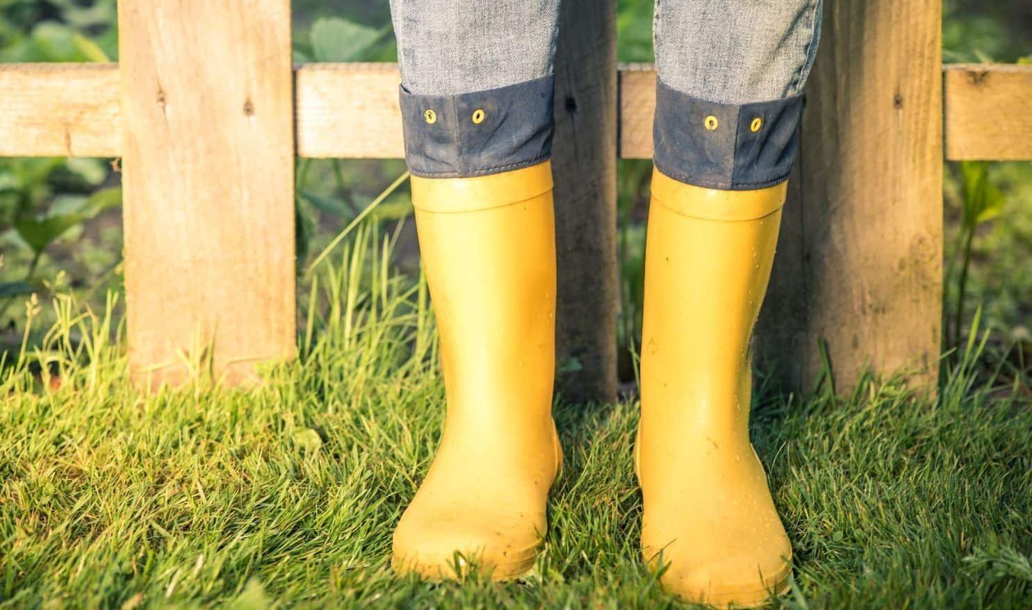 Person standing in a grass in wellies ready to take on a messy sewage repair job