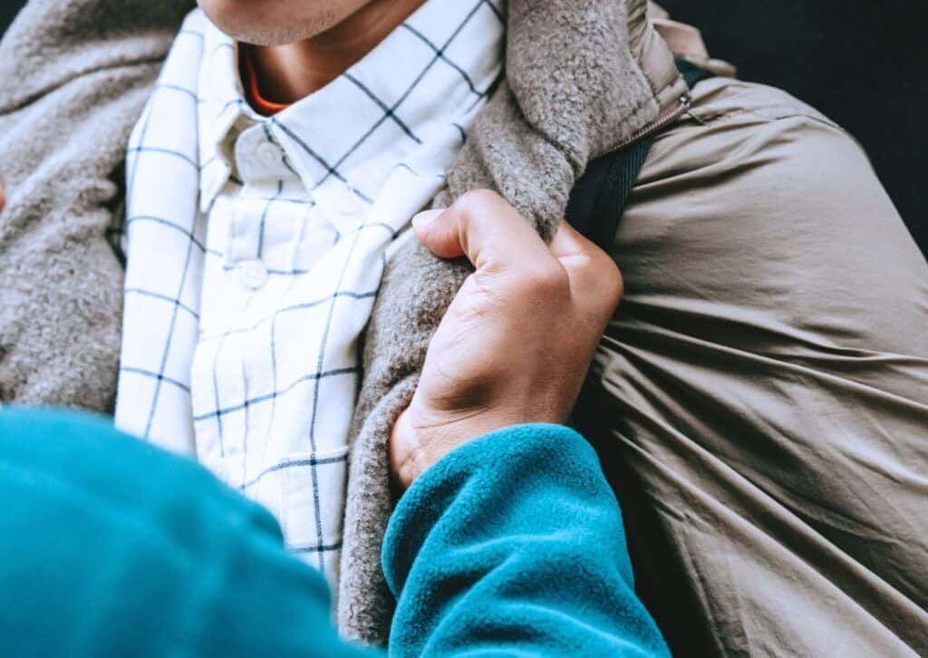 Man grabbing another man by his collar aggressively