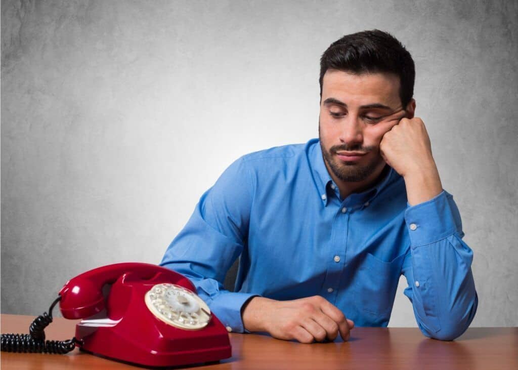 Man waiting by a telephone